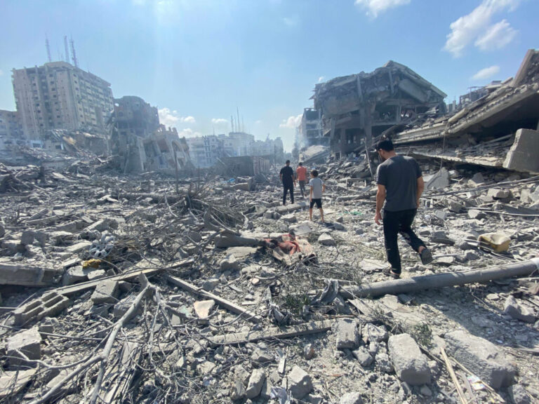 Palestinians inspect the damage following an Israeli airstrike on the El-Remal area in Gaza City