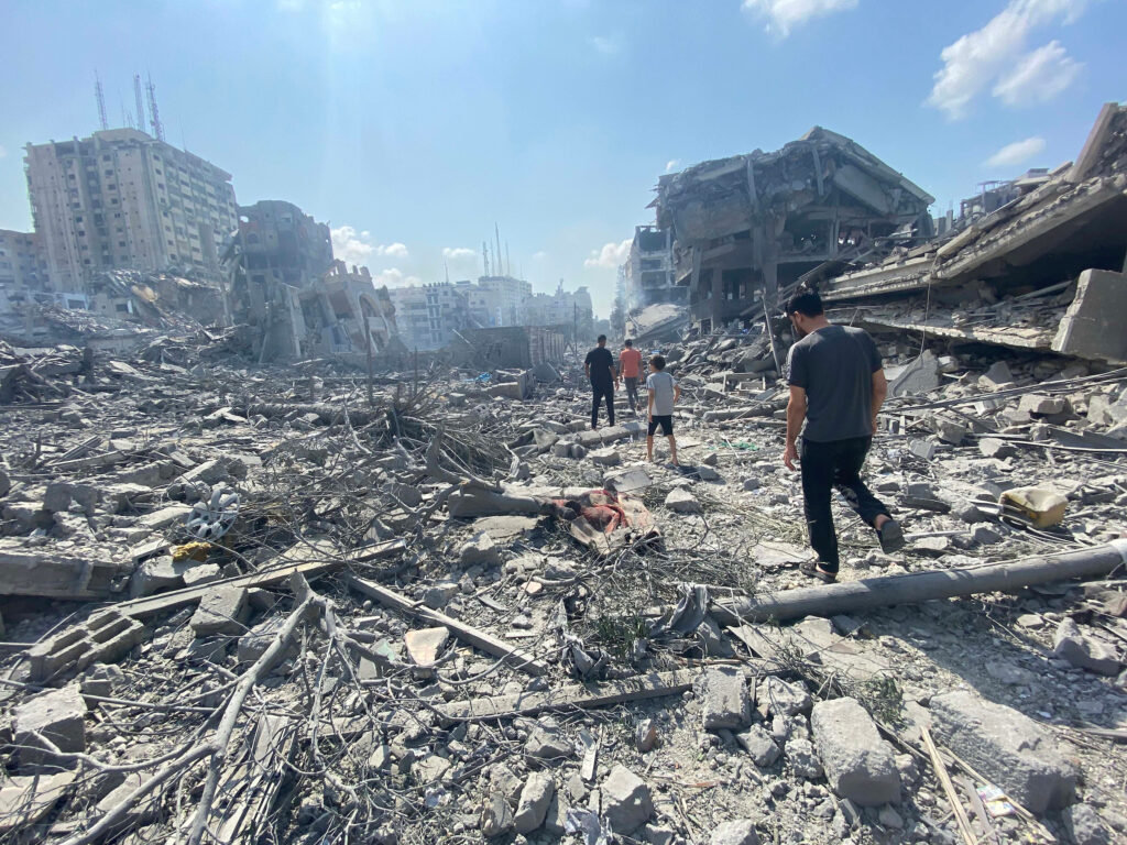 Palestinians inspect the damage following an Israeli airstrike on the El-Remal area in Gaza City